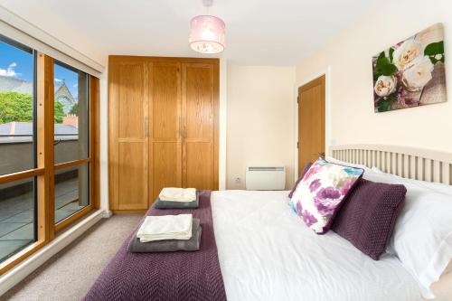 a bedroom with a bed and a large window at Apartment 144 - Clifden in Clifden