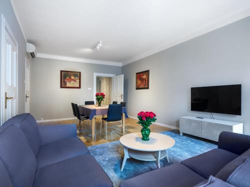 a living room with a blue couch and a table at Apartments Rynek Glowny in Krakow