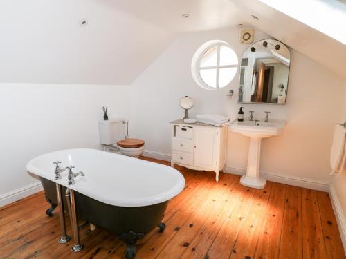 a bathroom with a bath tub and a sink at The Old Stables in Newquay