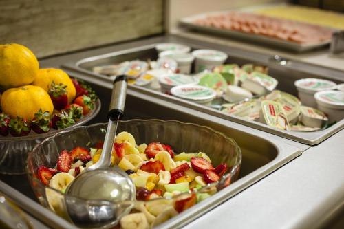 Un buffet con varias bandejas de frutas y verduras. en Facón Del Mar Hotel, en Mar del Plata