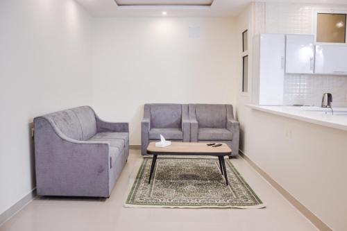 ein Wohnzimmer mit einem Sofa und einem Couchtisch in der Unterkunft روز للشقق الفندقية in Hotat bani tamim