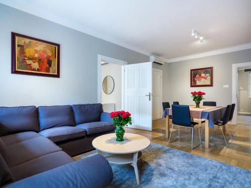 a living room with a blue couch and a table at Apartments Rynek Glowny in Krakow