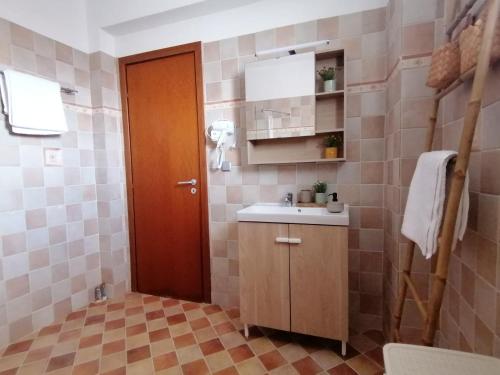 a bathroom with a sink and a wooden door at Native Living in Polykhrono