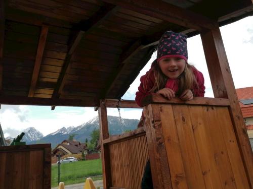 a little girl in a wooden play house at Chata Klaudi a Vilko in Veľký Slavkov