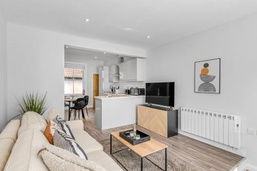 a living room with a couch and a kitchen at Surrey Street Duplex in Norwich