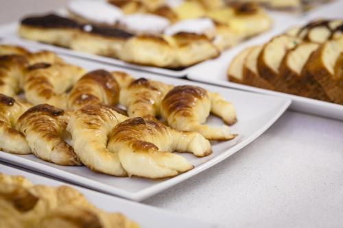 Un montón de pasteles en platos sobre una mesa. en Facón Del Mar Hotel, en Mar del Plata