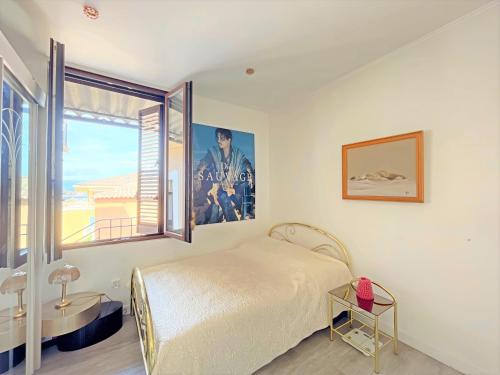 een slaapkamer met een bed en een groot raam bij Apartment beach acces Theoule sur mer in Théoule-sur-Mer