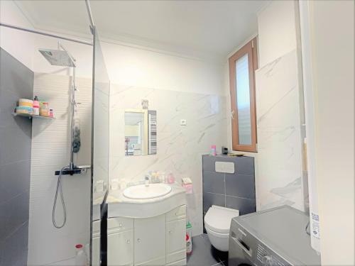 une salle de bain blanche avec un lavabo et des toilettes dans l'établissement Apartment beach acces Theoule sur mer, à Théoule-sur-Mer