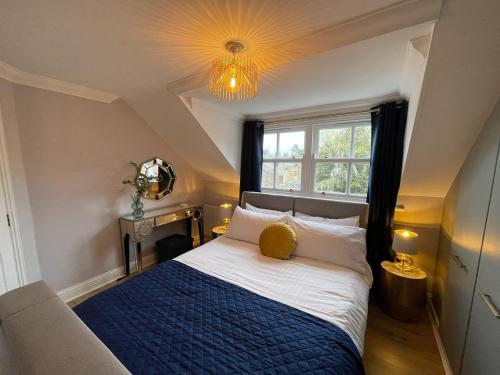 a bedroom with a bed with a blue blanket and a window at Luxury Boutique Apartment - Amazing City Location in Cambridge