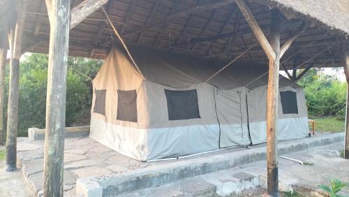 uma tenda que está sob um telhado de madeira em Engiri Game Lodge and Campsite em Katunguru