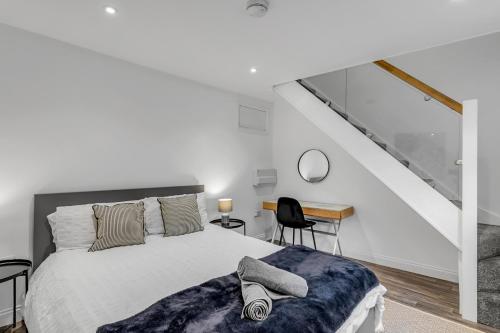 a white bedroom with a bed and a desk at Surrey Street Duplex in Norwich
