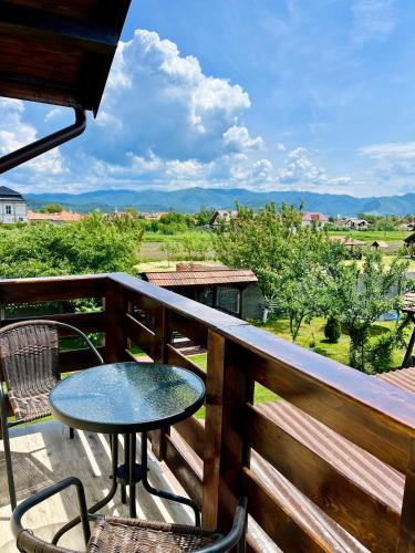 a table and chairs on a balcony with a view at Vila SOFIA in Haţeg