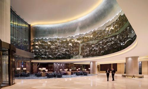 JW Marriott Hotel Chongqing في تشونغتشينغ: لوبي فيه لوحة كبيرة على السقف