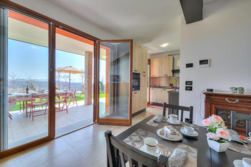 une cuisine et une salle à manger avec une table et une salle à manger avec une terrasse dans l'établissement Villa Teresa Apt Lake Garda View - Happy Rentals, à Soiano del Lago