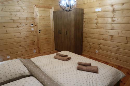 a bedroom with a large bed with two towels on it at Chata Klaudi a Vilko in Veľký Slavkov