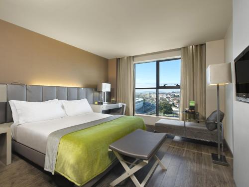 a hotel room with a bed and a large window at Melia Braga Hotel & Spa in Braga
