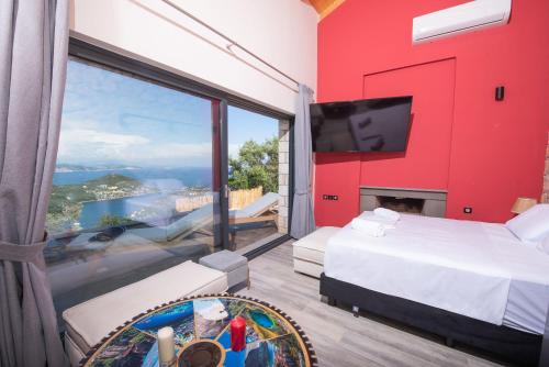 una camera da letto con una parete rossa e una grande finestra di Sivota Lefkas Luxury Villas a Sivota