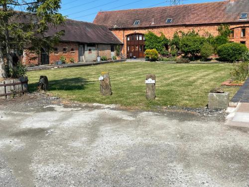 a yard with three wooden posts in front of a building at Irelands Farm Cottages in Birmingham