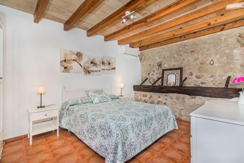 ein Schlafzimmer mit einem Bett in einem Zimmer mit Holzdecken in der Unterkunft Can De L'ausina in Pollença