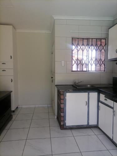 a kitchen with a counter and a window in it at Best of Pearls Guesthouse in Empangeni