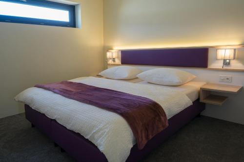 a bedroom with a large bed and a window at wohnMOTEL - Hinterforst in Altstätten