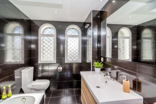 a bathroom with a white sink and a toilet at Tropical Getaway Townhouse in Nueva Andalucia close to Los Naranjos Golf in Marbella