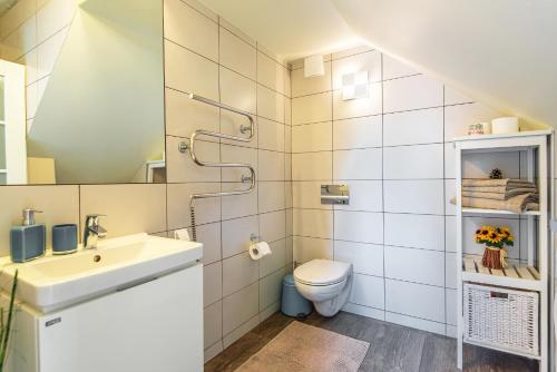 La salle de bains est pourvue d'un lavabo et de toilettes. dans l'établissement Žalia Kopa apartamentai, à Palanga