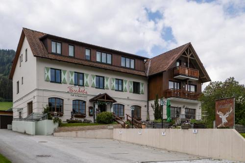 a large white building with a brown roof at Geierkogel Retreat in Hohentauern