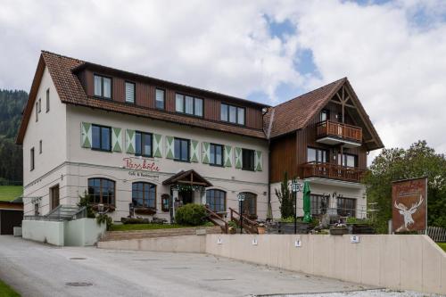 a large white building with a brown roof at mivida - Apartment Geierkogel in Hohentauern