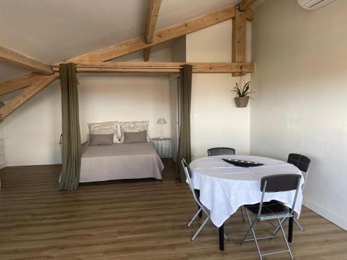1 dormitorio con 1 cama y 1 mesa con sillas en STUDIO 40 m² avec parking en Montauban