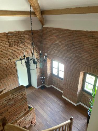 einen Blick über ein Wohnzimmer mit Ziegelwand in der Unterkunft STUDIO 40 m² avec parking in Montauban