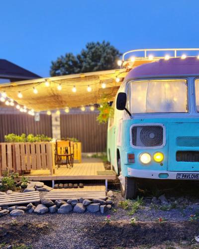 蓋貝萊的住宿－Pavlove Tiny Bus House in Qabala，停在带甲板的院子中的蓝色货车