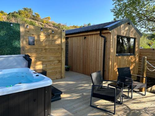 a hot tub on a deck next to a building at River Huts with Private Hot Tubs in Inverness