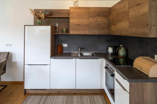 a kitchen with white cabinets and a white refrigerator at Geierkogel Retreat in Hohentauern