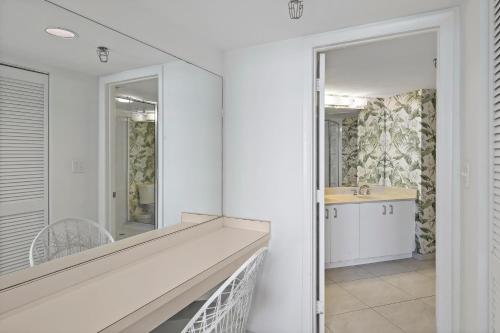 ein weißes Badezimmer mit einem Waschbecken und einem Spiegel in der Unterkunft Somerset 203 in Marco Island