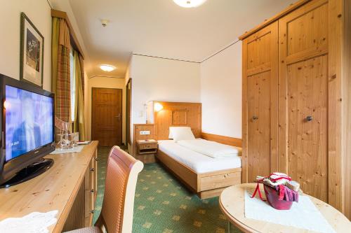 een hotelkamer met een bed en een televisie bij Alpenrast Tyrol in Mils bei Imst