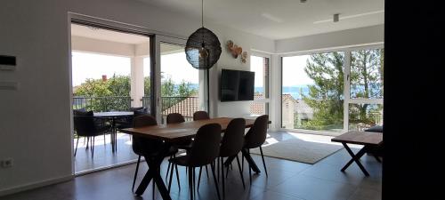 奈維斯的住宿－Seabreeze Luxury Apartments，一间带桌椅的用餐室和一个阳台