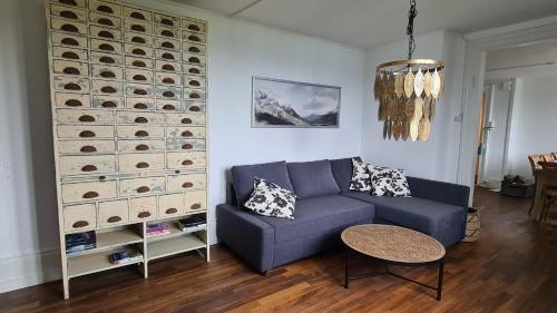 a living room with a couch and a wall of wine bottles at Swiss Holiday Apartments in Spiez