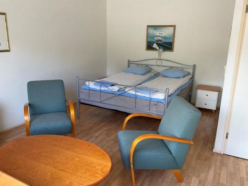1 dormitorio con 1 cama, 2 sillas y mesa en Posio Apartments, en Posio