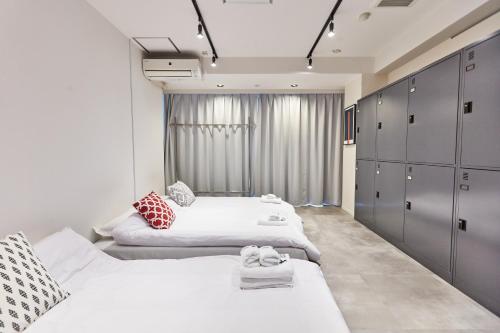 a bedroom with two beds and a large window at Tora Hotel Asakusa in Tokyo