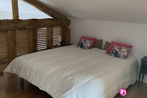 une chambre avec un grand lit blanc avec des oreillers rouges dans l'établissement Oestuaire, à Gauriac