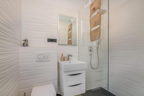 a bathroom with a toilet and a sink and a shower at Tea Deluxe Apartment with private Pool in Malinska