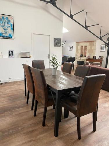 une table à manger et des chaises dans un salon dans l'établissement Loft proche centre ville Hôtes habitant à l étage, à Laval