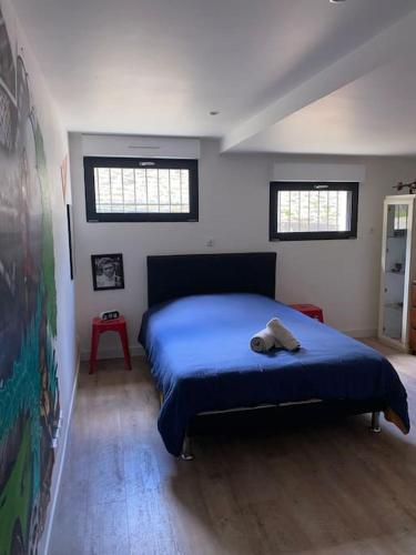 - une chambre avec un lit avec une couverture bleue et 2 fenêtres dans l'établissement Loft proche centre ville Hôtes habitant à l étage, à Laval