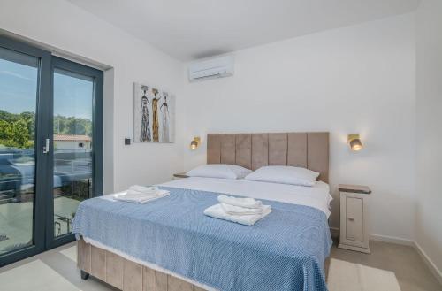 a bedroom with a bed with towels on it at Tea Deluxe Apartment with private Pool in Malinska