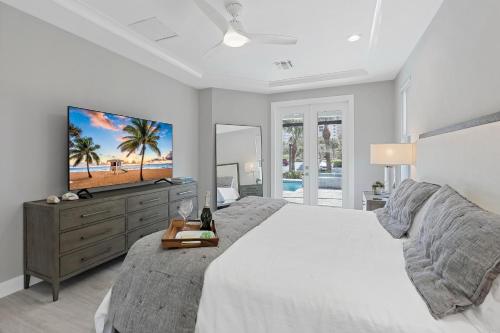 a white bedroom with a large bed and a tv at 280 West Flamingo Circle in Marco Island