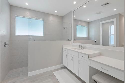 a white bathroom with a sink and a mirror at 280 West Flamingo Circle in Marco Island