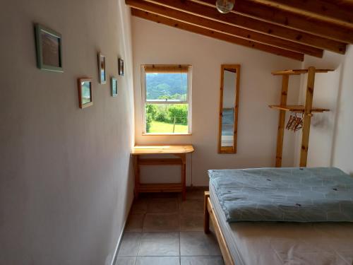 Cosy Private Cottage w/sea views & wifi في فيلا دو بورتو: غرفة نوم بسرير ونافذة