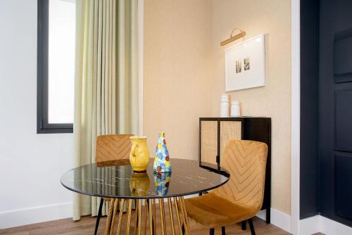 a dining room with a glass table and two chairs at Genteel Home Betis 67 in Seville