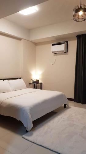 a bedroom with a white bed and a air conditioner at 101 Newport blvd C2 4F by Rechelle Nunag in Manila